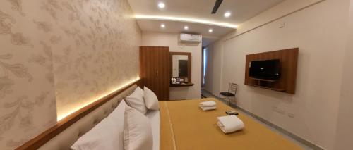 a hotel room with a bed and a tv at UK Comforts in Bangalore