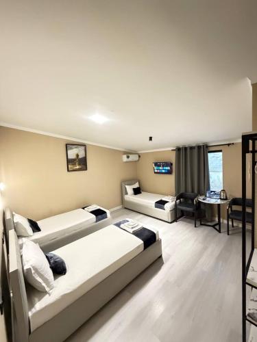 a hotel room with two beds and a living room at Luna Plaza Hotel in Lunacharskiy Bekati