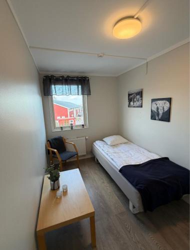 a bedroom with a bed and a table in it at Bryggans Vandrarhem in Västervik