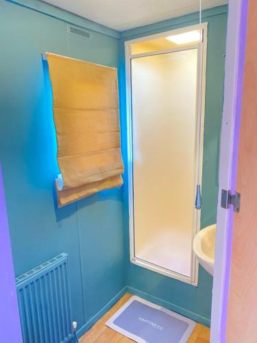 a bathroom with a shower and a sink and a towel at PD Wonderwall Caravan, Direct beach access & Beds made on arrival & GCH in Ingoldmells