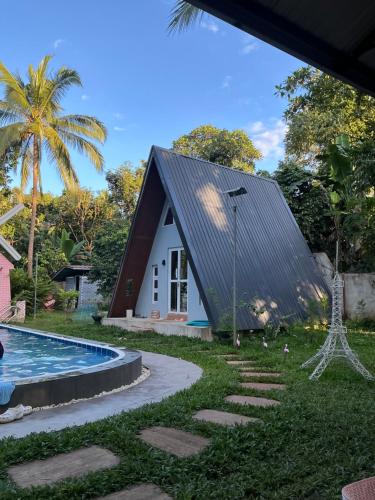 a house with a black roof and a swimming pool at The Siblings Farm House in Liliw