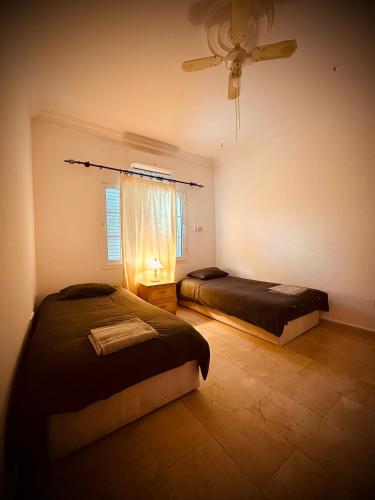 a bedroom with two beds and a ceiling fan at Villa Lapethos in Kyrenia