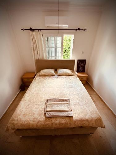 a large bed in a room with a window at Villa Lapethos in Kyrenia