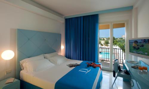 a bedroom with a bed and a view of a pool at Domina Zagarella Sicily in Santa Flavia