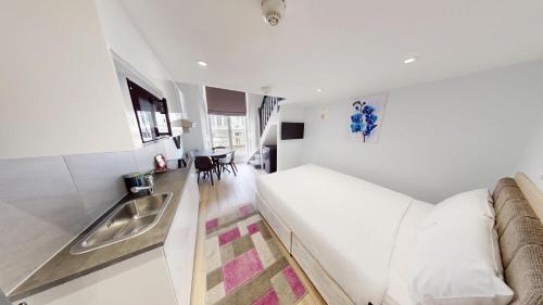 a white room with a bed and a sink at MSK Premium in London