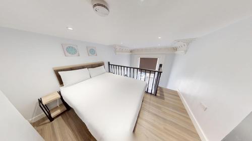 a bedroom with a white bed and a staircase at MSK Premium in London