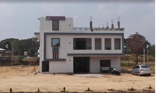 a building with a car parked in front of it at Salt Restaurant and Lodging in Navalgund