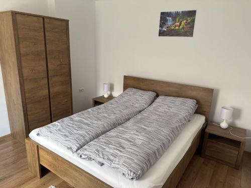a bed in a room with two night stands and two lamps at Casa Lemnarului in Micfalău