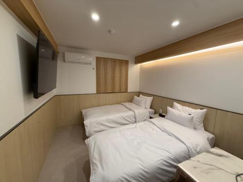 a room with two beds and a television in it at Latree Hotel in Seoul