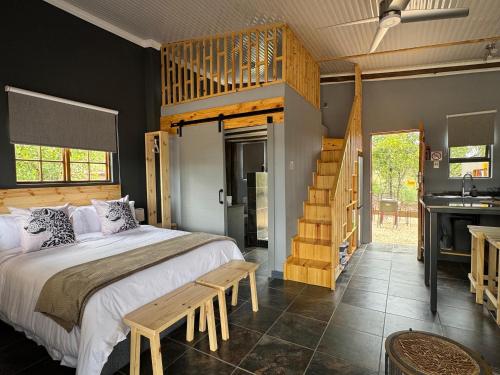a bedroom with a large bed and a staircase at Boskoors in Hammanskraal
