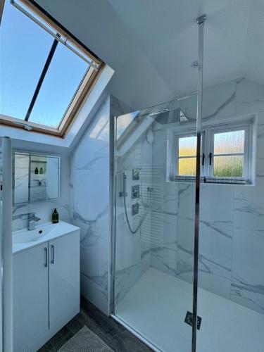 a white bathroom with a shower and a sink at Marie House in Bowness-on-Windermere