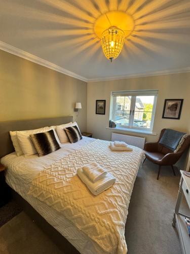 a bedroom with a large bed and a chandelier at Marie House in Bowness-on-Windermere