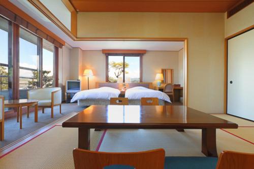 una stanza con una camera da letto con un letto e un tavolo di Shiki Resort Hida Takayamaso a Takayama