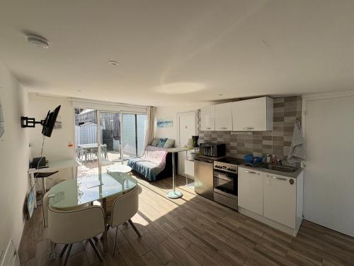 a kitchen and living room with a table and a dining room at La cabine de plage in Batz-sur-Mer