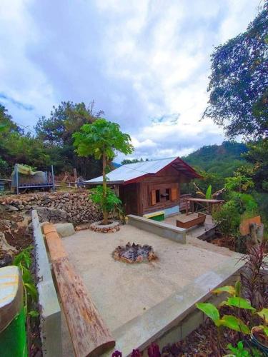 a small house with a patio and a building at Joan's All Seasons Homestay in Taccon