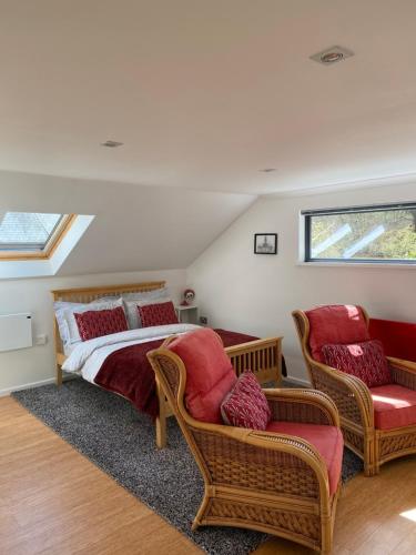 a bedroom with a bed and two chairs at Cedar Lodge in Torpoint
