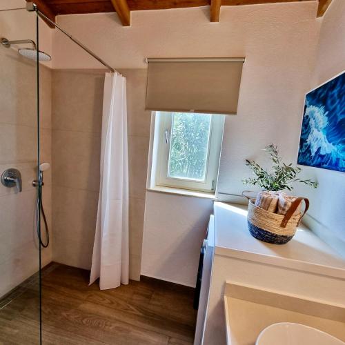 a bathroom with a shower curtain and a window at The House of Waves in Kotrónion