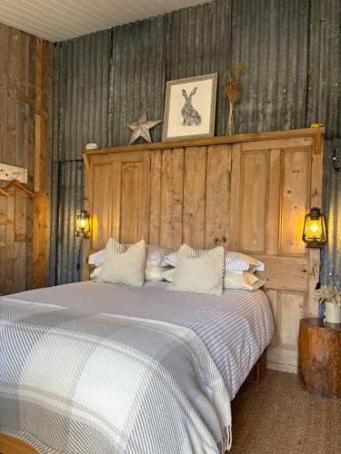 a bedroom with a large bed with a wooden headboard at The Pig and Sty in Hereford