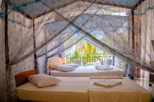 a bedroom with two beds in a tent at Lake Edge Resort in Hambantota