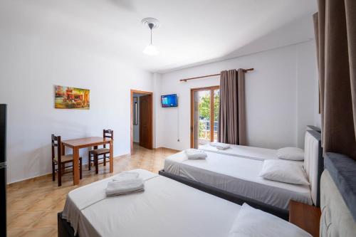 a hotel room with two beds and a table at Cozy Apartments Downtown in Ksamil