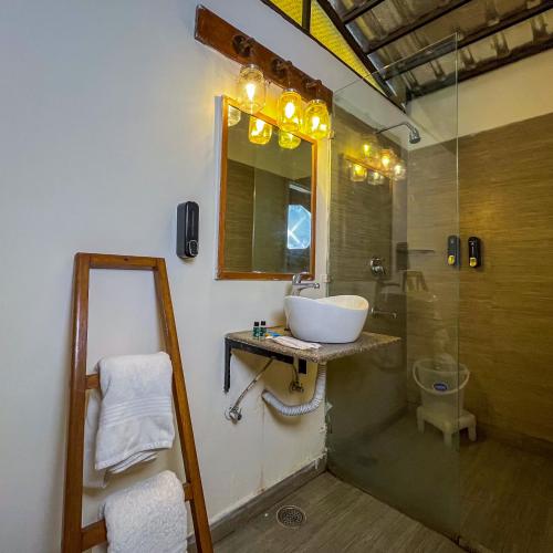 a bathroom with a sink and a mirror and a toilet at Aspen Riverside Resort in Rishīkesh