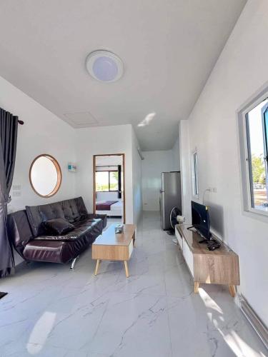 a living room with a couch and a table at Lamae Beachfront Villa in Ban Laem No