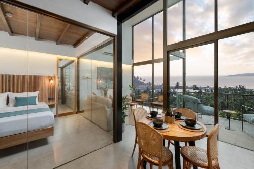 a bedroom with a bed and a table with chairs at The Loft Mirissa in Mirissa