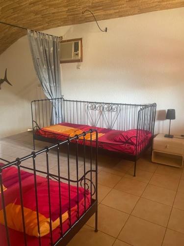 a bedroom with two bunk beds with red sheets at Superbe villa avec piscine privée à 500m de la plage à Nianing in Nianing