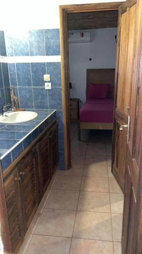a bathroom with a sink and a bed at Superbe villa avec piscine privée à 500m de la plage à Nianing in Nianing