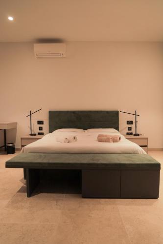 a bed in a bedroom with two towels on it at Sunset Edge Villa - 77 Retreats in Għajn Tuffieħa