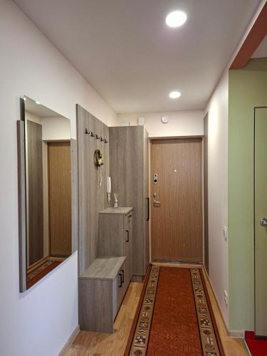 a bathroom with a bench and a shower and a door at Prie Masčio ežero in Telšiai