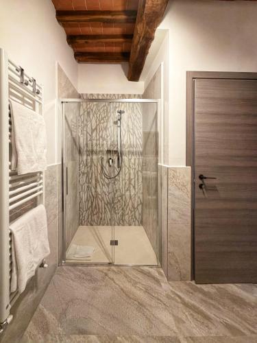 a shower with a glass door in a bathroom at Guardastrada Country House in Monteroni dʼArbia