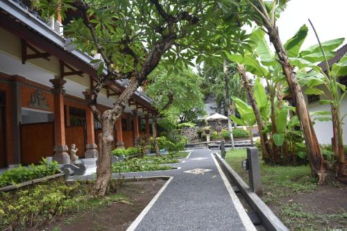 a path in front of a building with trees at Bendesa Accommodation in Kuta