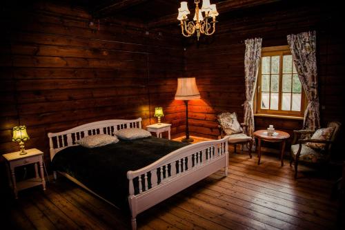 a bedroom with a bed in a log cabin at Atpūtas un sporta komplekss Mednieki - atpūta dabā, pie ezera in Salainis