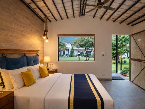a bedroom with a large bed and a large window at Aspen Riverside Resort in Rishīkesh