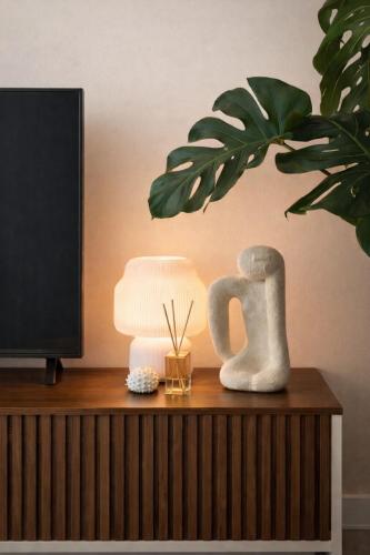 a table with a lamp and a plant on it at Apê 202 - Central, Garagem e Ar Cond - 2Q e 2B in Governador Valadares