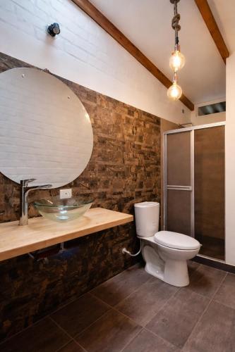 a bathroom with a toilet and a sink and a mirror at Villa Luz Hotel in Silvia