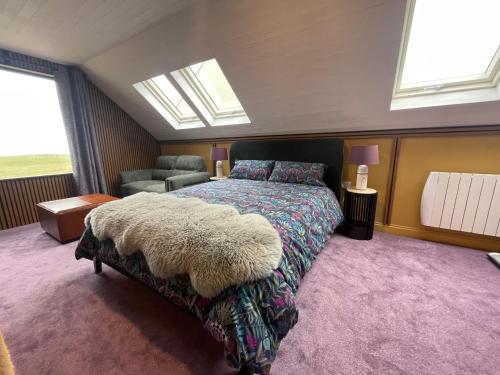 a bedroom with a bed with a rug on it at Seaside Suite Quilty in Quilty