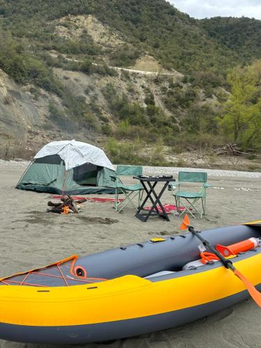 a yellow kayak and a table and a tent at Wild Camping Vjosa in Përmet
