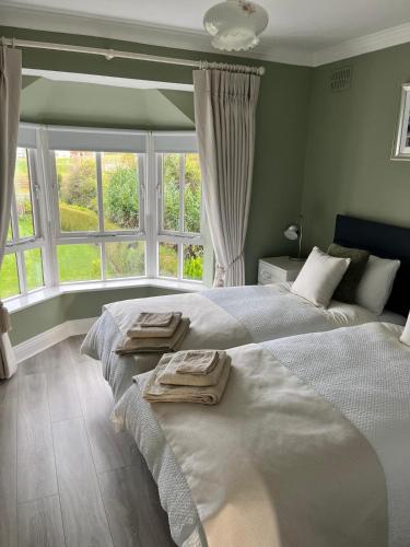 a bedroom with two beds and a large window at Big Pop's House in Kilmacthomas