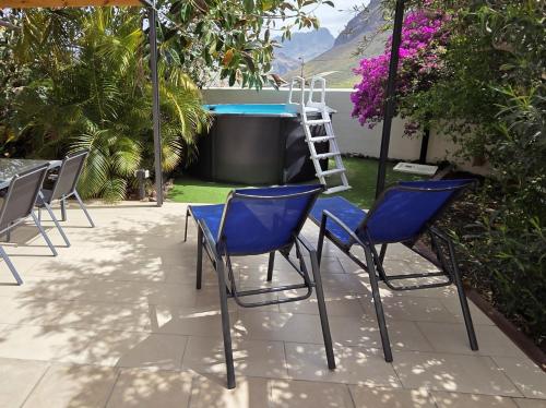 a group of chairs sitting around a pool at Casa Rural Anais in San Nicolás
