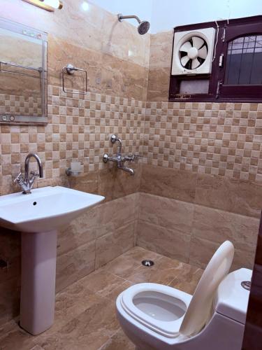 a bathroom with a toilet and a sink at Your Cozy Escape in Jammu