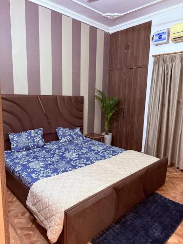 a bedroom with a bed with a blue comforter at Your Cozy Escape in Jammu