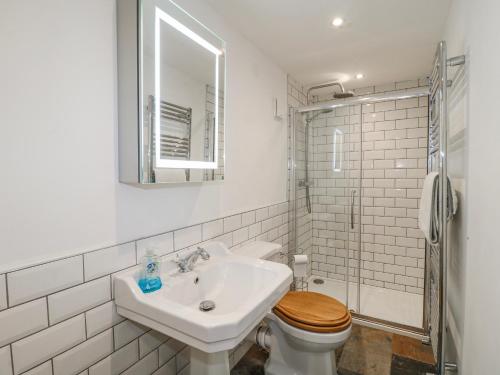a white bathroom with a sink and a toilet at The Granary Barn at America Lodge in Oakham