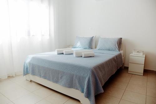 a bedroom with a bed with blue and white sheets at Toma Villa in Paralimni
