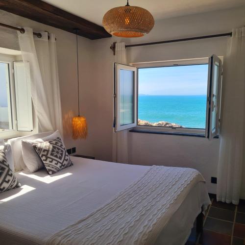 a bedroom with a bed with a view of the ocean at Casa das Marés 3 in Baleal