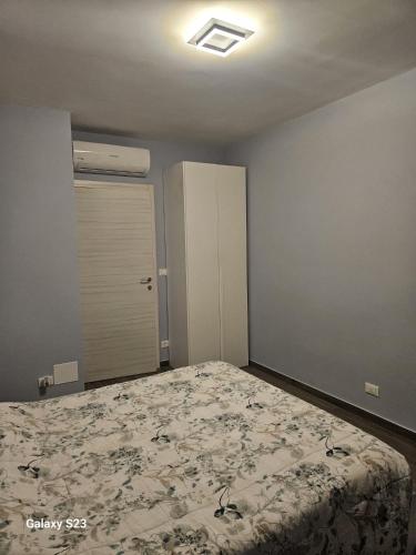 an empty bedroom with a bed and a door at Appartamento Torri del Benaco in Torri del Benaco
