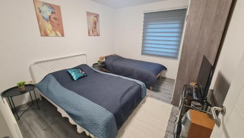 a room with two beds and a television in it at Vila MM Boračko jezero in Konjic
