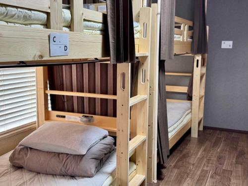 a room with two bunk beds with a pillow at 木の家ゲストハウス前橋本館 in Maebashi