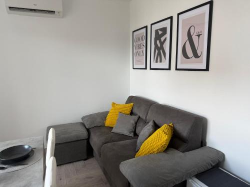 a living room with a gray couch and yellow pillows at Valuna - Modern Sea View Apartment -Terrace - 4 Min to Beach - Free Parking in Jadranovo